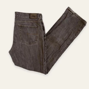 Grå jeans 32x33 - Säljer ett par jeans från sand jeans i superbra skick. Storlek 32x33. Kan gå ner i pris vid snabb affär             Midja: 88cm Innerbenslängd: 80cm Fotvidd: 21/42cm