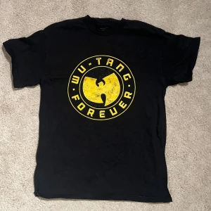 Svart Wu-Tang Forever t-shirt - Snygg wu-tang merch i svart. Tröjan har endast en gång tvättats och endast en gång använts (så gott som ny). Tröjan är i storlek M men skulle säga passar S (därav den säljs). Nypris: 500kr. Skriv om du har någon fundering..
