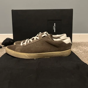 Saint Laurent suede trainer Skor  - Tjena! Säljer dessa tvär feta SL skor för en billig peng då dom är för små samt tagit lite skada längst med vägen. Box 📦, Extra skosnören (bruna), dustbag medföljer vid köp. Nypris på dessa runt 7000 kr men säljes nu för 1799. Vid snabb affär kan priset diskuteras🙌🏽 