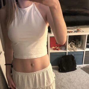 Vit croppad linnetopp från Bik Bok - Säljer en stilren vit croppad linnetopp från Bik Bok. Toppen har en knytning i nacken och är ärmlös, perfekt för varma sommardagar. Enkel och snygg design som passar till det mesta. 🌞Aldrig använd, skriv för mer information💕