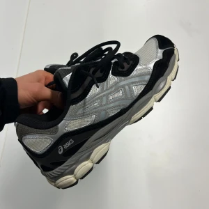 Svarta och silverfärgade sneakers från Asics - Säljer ett par snygga Asics sneakers i svart och silver. Tvär sköna och passar perfekt till ett par mjukisbyxor eller jeans. Kontakta PM för frågor eller intresse. Priset kan diskuteras.