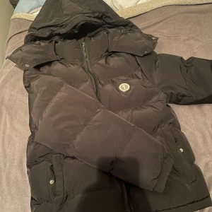 Svart pufferjacka från Trapstar - Snygg svart pufferjacka från Trapstar med broderad logga på ryggen. Removable Hood. 7500 på StockX