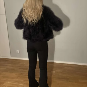 Svart pälsjacka - Snygg och fluffig svart pälsjacka som skiftar mot den blåa färgen! 