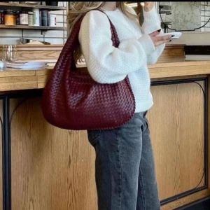 Röd flätad axelväska från YAMZ - Säljer en snygg röd axelväska i flätat mönster. Väskan har en dragkedja upptill och är rymlig, många bra fack inuti. Väskan är från yamz och är helt oanvänd! Nypris 650kr Perfekt som julklapp!!