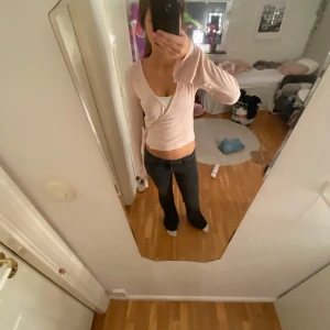 Ljusrosa omlottopp - Säljer en superfin ljusrosa omlottopp med långa ärmar och knytband i midjan. Perfekt för både vardag och fest! Den är gjord i ett mjukt och bekvämt material som sitter snyggt på kroppen. Använd fåtal gånger och bra skick men lånad bild😊