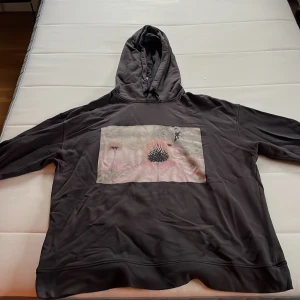 Svart hoodie med tryck - Säljer en svart hoodie med ett coolt tryck på framsidan. Perfekt för en avslappnad stil och passar bra till både jeans och joggers tröjan har en bekväm huva. Perfekt för höst och vinter!
