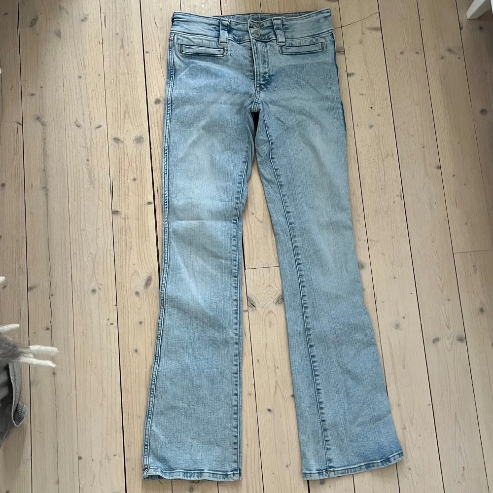 Säljer ett par ljusblå bootcut jeans från H&M i storlek 170. De har låg midja och justerbar midja för perfekt passform. Skicket är bra och de är superbekväma att ha på sig. Midjemått: 36cm Innerbenslängd: 77cm. Jeans & Byxor.