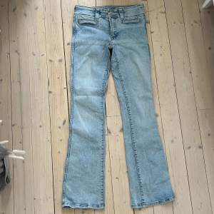 Säljer ett par ljusblå bootcut jeans från H&M i storlek 170. De har låg midja och justerbar midja för perfekt passform. Skicket är bra och de är superbekväma att ha på sig. Midjemått: 36cm Innerbenslängd: 77cm