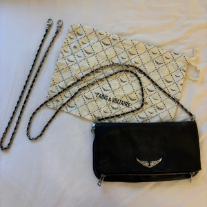 Zadig & Voltaire väska  - Snygg svart axelväska från Zadig & Voltaire. Väskan har en avtagbar kedjerem, med både den korta och långa remmen. Köpt på plick för 2 år sedan, säljer på grund av att den inte kommer till användning längre💗