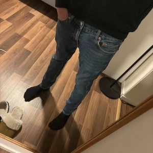 Weekday jeans - Säljer ett par klassiska blå jeansbyxor i mycket bra skick. De har en slim passform och är perfekta för både vardag och fest. Byxorna har en dragkedja och knappar framtill. Perfekta för höst och vår!