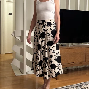 Blommig kjol - Vit och svartblommig vadlång kjol. Kommer från hm och är i strl 36. Oanvänd