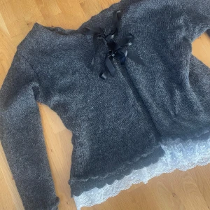 Vacker kofta stl XL - Superfin kofta i bomull/ull. Mörkgrå med vita spetskanter. Står ingen storlek men uppskattar den till XL.