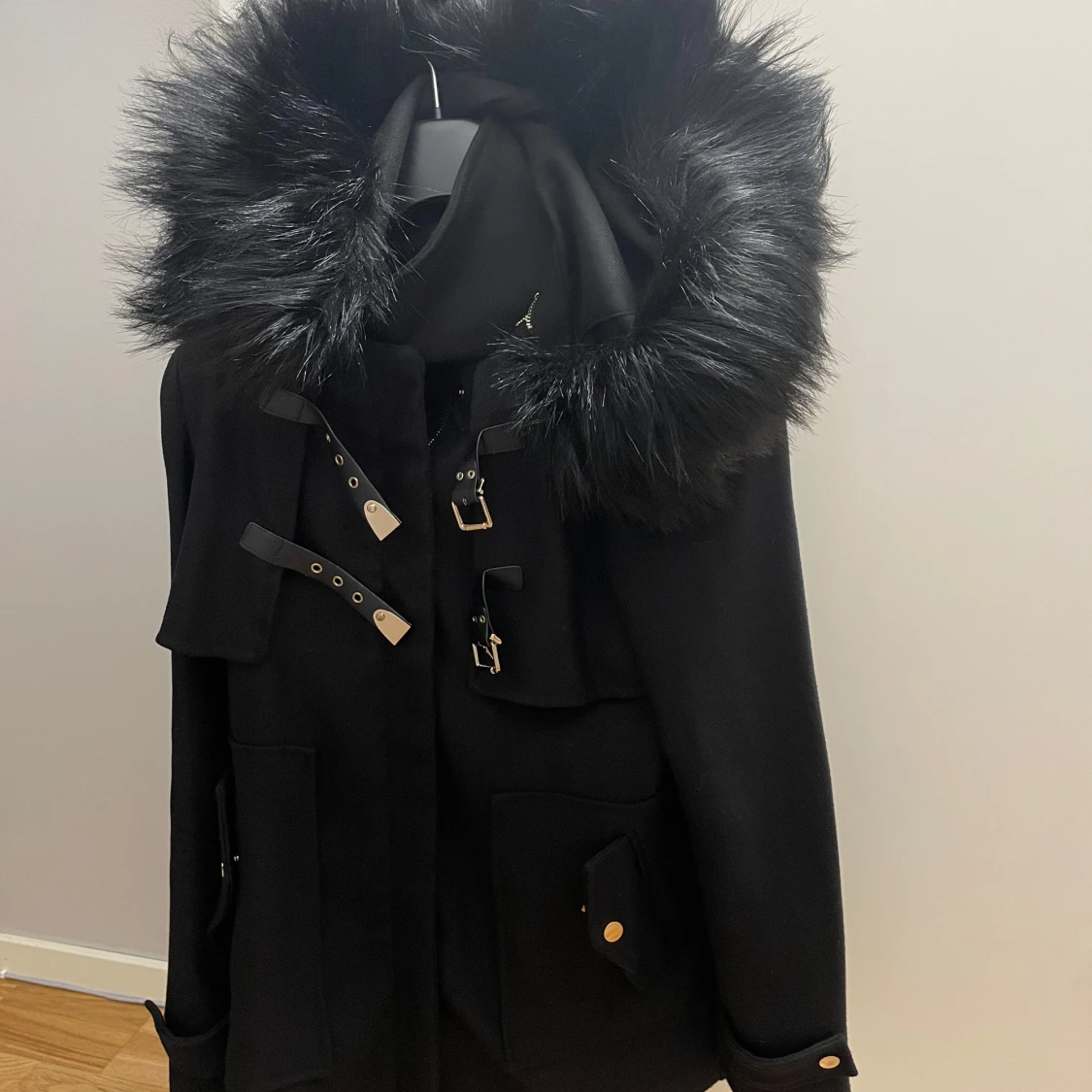 Svart kappa med pälsdetaljer