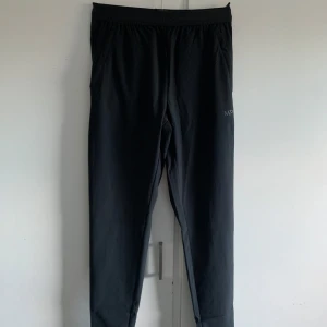 Svarta träningsbyxor från MP - Säljer ett par svarta träningsbyxor från MP i storlek XS. De är perfekta för träning med en bekväm passform och elastisk midja. Byxorna är tillverkade i ett mjukt och stretchigt material som ger bra rörelsefrihet. Helt ny. Aldrig använd. Orginalförpakning följer med. 