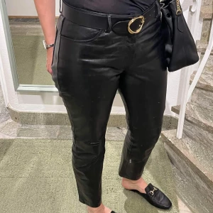 Skinnbyxor i 100 % skinn, stl 12 (ca 40-42) - Klassiska skinnbyxor i 5-ficksmodell, så snygga och väldigt användbara! I skick utan anmärkning. Stl 12, uppskattar det till stl 40-42. 
