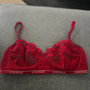 Röd lounge bh - Röd spets lounge bh, 75 E. Använd ca 2 gånger! Säljer pågrund av att jag behöver en större storlek. 100kr