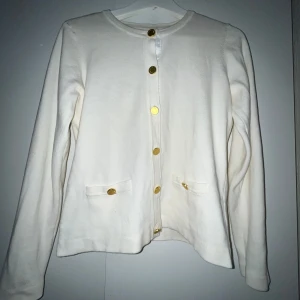 Vit kofta  - Vit kofta med guldknappar i jättebra skick🤍 Liten defekt på bild 3 men inget märkvärdigt. Nypris 599 kr men denna säljs inte längre 