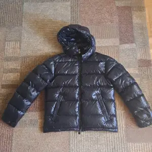 Helt ny och oanvänd Moncler Maya jacka i storlek 4 (M/L). Originaletiketter och Moncler-fodral ingår. Jackan är av hög kvalitet och perfekt för vintern. Tyvärr var storleken för liten för mig. Ingen retur accepteras. Kontakta mig vid intresse!