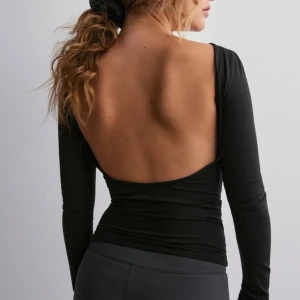 Gina Tricot Low Back Top - Svart långärmad tröja från Gina Tricot med låg/öppen rygg. Använd 1-2 ggr