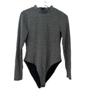 Grå långärmad bodysuit - Snygg och stilren grå långärmad bodysuit med hög hals. Perfekt för en chic och modern look. Passar bra till både vardag och fest!
