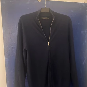 Mörkblå kashmirtröja från Matinique - Säljer en elegant mörkblå kashmirtröja från Matinique med dragkedja framtill. Tröjan har en stilren design med långa ärmar och en hög krage. Perfekt för att hålla sig varm och snygg under kyliga dagar. Köpt för 2.200k, Priset går självklart att diskutera.