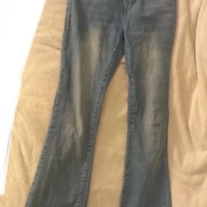 Blå jeans med bootcut - Säljer ett par klassiska blå jeans med bootcut. De har en snygg tvättad look och är perfekta för en avslappnad stil. Jeansen har fickor både fram och bak.