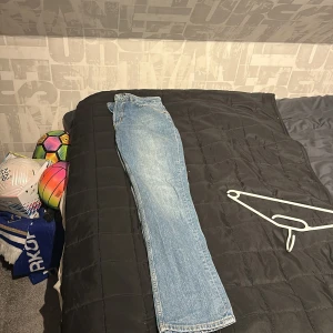 Blå jeansbyxor - Säljer ett par klassiska blå jeansbyxor i en snygg straight stil. Perfekta för en avslappnad look. De har en traditionell femficksdesign och är tillverkade i slitstarkt denim.