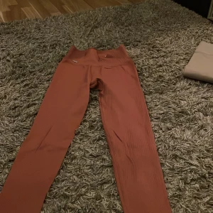 Typ rosa ribbade leggings från Aim'n - Snygga typ rosa leggings från Aim'n med ribbad textur. Perfekta för både träning och avslappning. De har en hög midja som ger en bekväm passform.