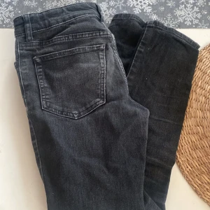 Svarta jeansbyxor - Snygga svarta jeansbyxor med klassisk femficksdesign. Perfekta för en stilren look och passar till det mesta. De har en rak passform och är tillverkade i ett slitstarkt material.