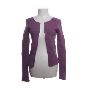 Lila kofta från Zadig & Voltaire - Säljer en snygg lila kofta från Zadig & Voltaire i 100% Geelong ull. Koftan har långa ärmar med svarta stjärnor på armbågarna och en öppen design framtill. Perfekt för att ge en färgklick till din outfit!