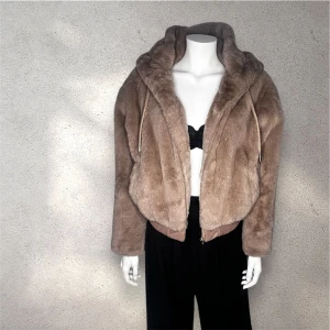 Zara beige faux pälsjacka med huva - Säljer en supermjuk och fluffig beige faux pälsjacka med huva från Zara.Jackan har en dragkedja framtill och ribbade muddar vid ärmslut och nederkant. Perfekt för att hålla sig varm och stilren under kyliga dagar. 🧥✨
