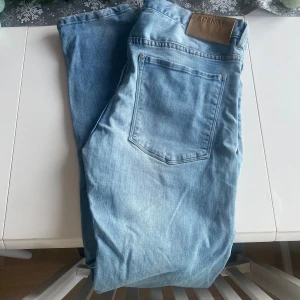 &DENIM jeans - Snygga ljusblå jeansbyxor med klassisk femficksdesign och en bekväm passform. De har en läderpatch med märkeslogga på baksidan av midjan. Perfekta för en avslappnad stil.