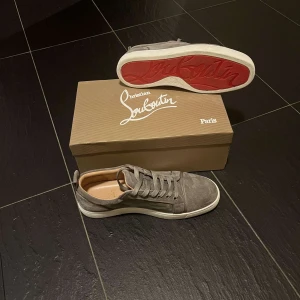 Grå sneakers från Christian Louboutin - Hej! Detta är ett par feta loubs i väldigt bra skick då dom endast är använda någon gång. Säljes då det inte är min stil. De är i storlek 43 och med skorna samt boxen följer tags och kvitto med. Tveka inte att höra av dig om du har några frågor eller funderingar. Billigare vid snabb affär.