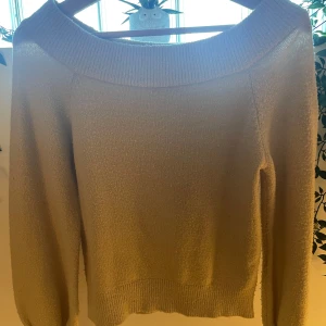 Beige off-shoulder tröja - Mysig beige stickad off-shoulder tröja från Gina Tricot. Ganska nopprig men fortfarande mjuk!Tröjan har långa ärmar och en bred ribbad kant vid halsen och ärmsluten. Storlek S men passar eventuellt XS
