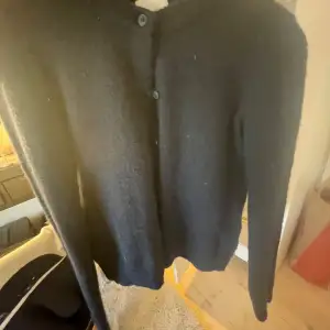 Säljer en mörkblå kofta från H&M, har långa ärmar och knappar framtill. Lite noppig men inget man tänker på