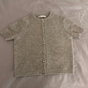 Grå kofta från Zara - Säljer nu min super fina kofta ifrån Zara med korta ärmar och silver pärlor! Den är i mycket bra skick och har bara andvänds ett par gånger! Hör av er om ni har några frågor eller vill ha flera bilder💗