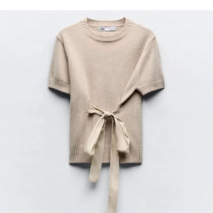 Topp med snörning  - Säljer en beige tröja från Zara med korta ärmar och ett knytband i midjan🥰