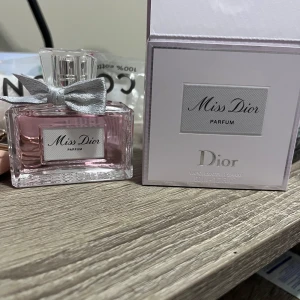 Miss Dior Parfum - Elegant parfym från Dior i en vacker glasflaska med rosa doftvätska. Flaskan pryds av en silverfärgad rosett vid korken, vilket ger en lyxig känsla. Perfekt för den som älskar en klassisk och sofistikerad doft. Köpt för en vecka sen. Knappt använt den