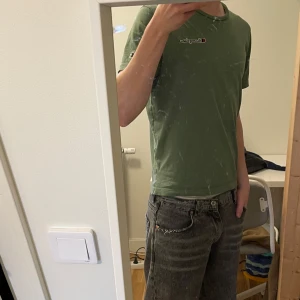 Grön Champion T-shirt  - Säljer min gröna Champion T-shirt i size S som tyvärr blivit för liten. Inga defekter bortsätt från ett litet hål (bild 4). Köpte i Champion affären för 400 kr så här har du ett kap!