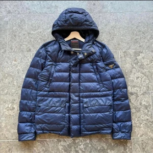 Prada dunjacka  - Tja! Säljer nu denna Prada dunjacka som är riktigt snygg! Den är i storlek medium och är i helt okej skick, det är en lagning men den syns inte när man använder den. Annars toppskick!!