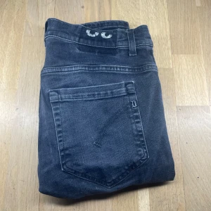 Dondup jeans - Snygga svarta dundup jeansbyxor med en slim passform. De har en klassisk femficksdesign och en diskret logga baktill. Perfekta för en stilren look.