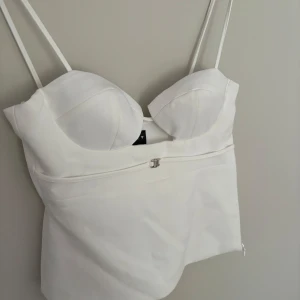Vit topp - Så fin vitt topp från Zara, passar S och XS! Helt slutsåld och nypris 329 kr. Aldrig använd men tyvärr är dragkedjan sönder och kan därför inte knäppas, därav det billiga priset! 💛
