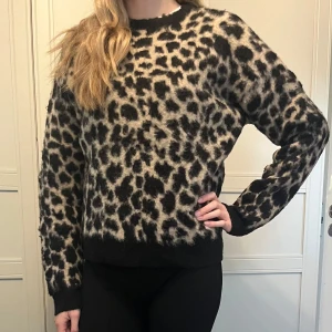 Leopard stickad tröja - Stickad tröja med leopardmönster från NA-KD 💕. Tröjan har använts flera gånger som man kan se på sista bilden då armen har slitits upp lite. Men inga hål eller fläckar 😊.