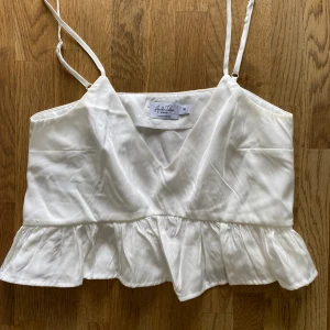 Vit topp från nakd  - Söt vit topp från Anika Tellers kollektion med NA-KD, limitted edition, går inte att köpa längre.  Storlek 36. Använd fåtal gånger! Silkeslikande material Hör av er vid frågor❤️