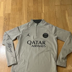 Psg träningströja  - Skick 9/10. Använd fåtal gånger. Köpt för 749 kr. Size 147-158 cm. färg grå beige. Pris kan diskuteras 