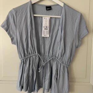 Ljusblå knyttopp - Oanvänd topp med prislapp. Köpt för 259kr.