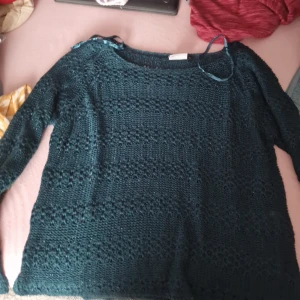 Mörkgrön stickad tröja från Gina - Säljer en superfin mörkgrön stickad tröja från Gina. Den har ett snyggt mönster och är perfekt för kyliga dagar. Tröjan är långärmad och i storlek L. Perfekt för höst och vinter! 🍂