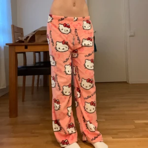 Rosa Hello Kitty mjukisbyxor - Supermysiga rosa mjukisbyxor med Hello Kitty-motiv över hela. Perfekta för en chill dag hemma eller som söta pyjamasbyxor. De är lösa och bekväma med en elastisk midja för extra komfort. 🐱💕 Passar XS-M jag är 165 Kontakta mig vid intresse!