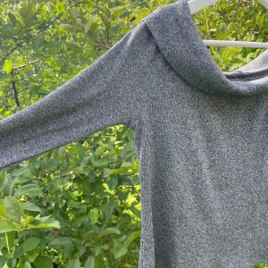 Topp - Smickrande stickad, men ändå tunn,  topp. 80% polyester och 20% viskos. Snygg ringning som vilar på axlarna.