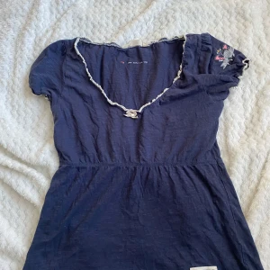 Odd Molly topp - Säljer en supersöt marinblå Odd Molly topp med en liten vit rosett på! Hittar ingen storlek men skulle gissa på S! Den är i fint skick, frakten ligger på 30 kr! Vintage!!!